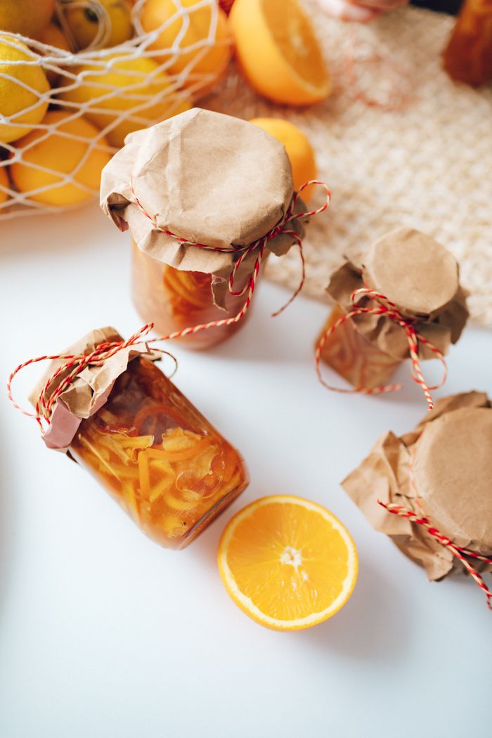 Contact Top view of homemade orange preserves in jars, beautifully wrapped with rustic paper and twine.