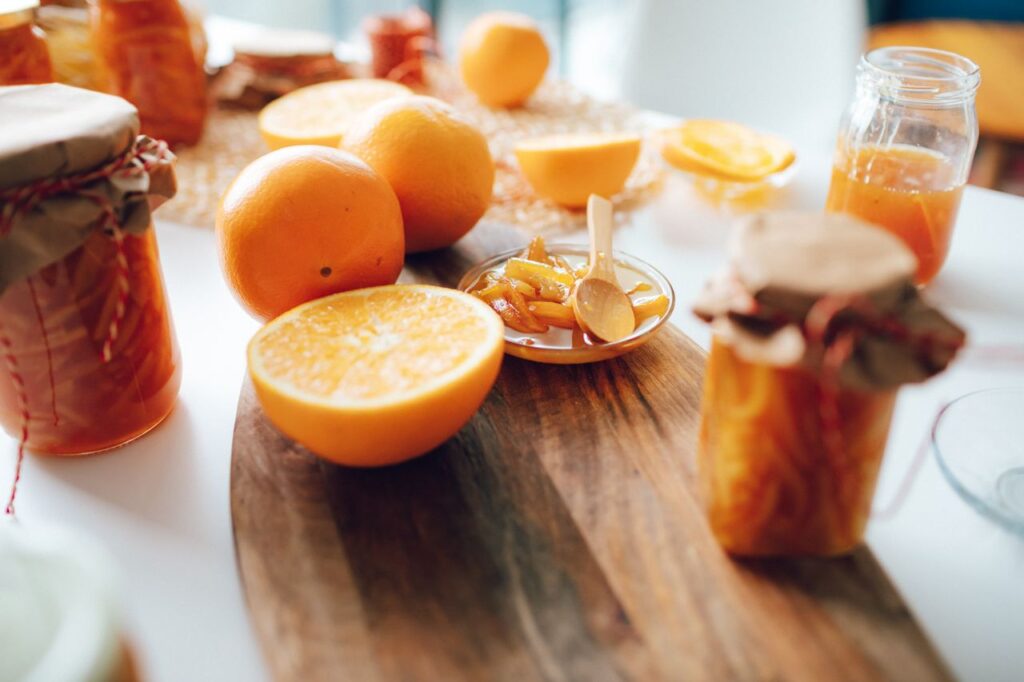pexels photo 6588617 Bright and fresh, homemade orange jam with sliced oranges on a wooden board.
